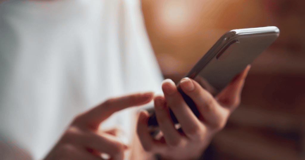 Person holding a smartphone and tapping the screen